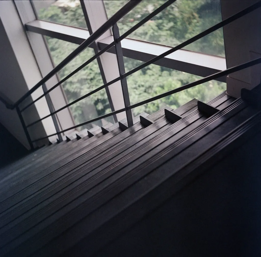 Escalera de metal oscuro junto a un ventanal