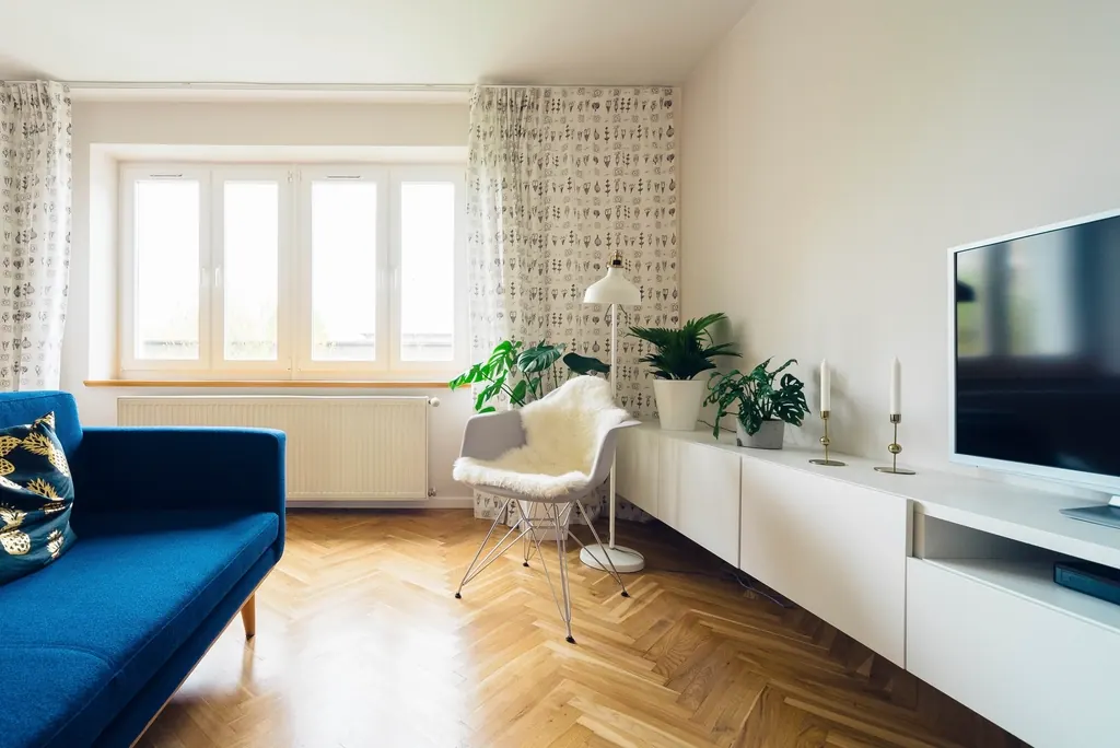 Salón luminoso con suelo de espiga y sofá azul