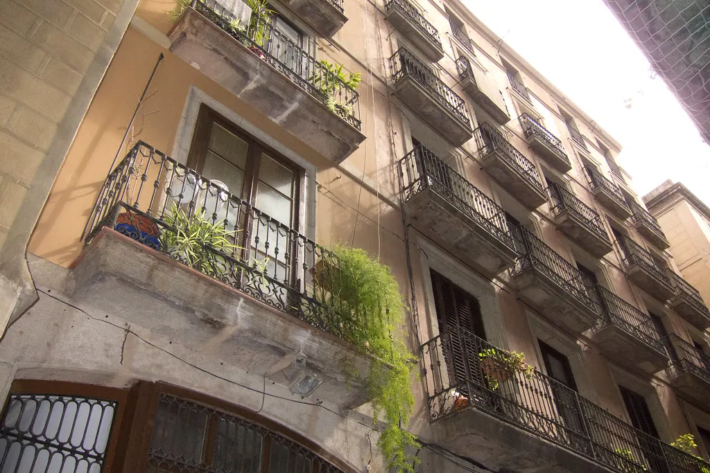 Balcones de hierro con plantas en una fachada del barrio