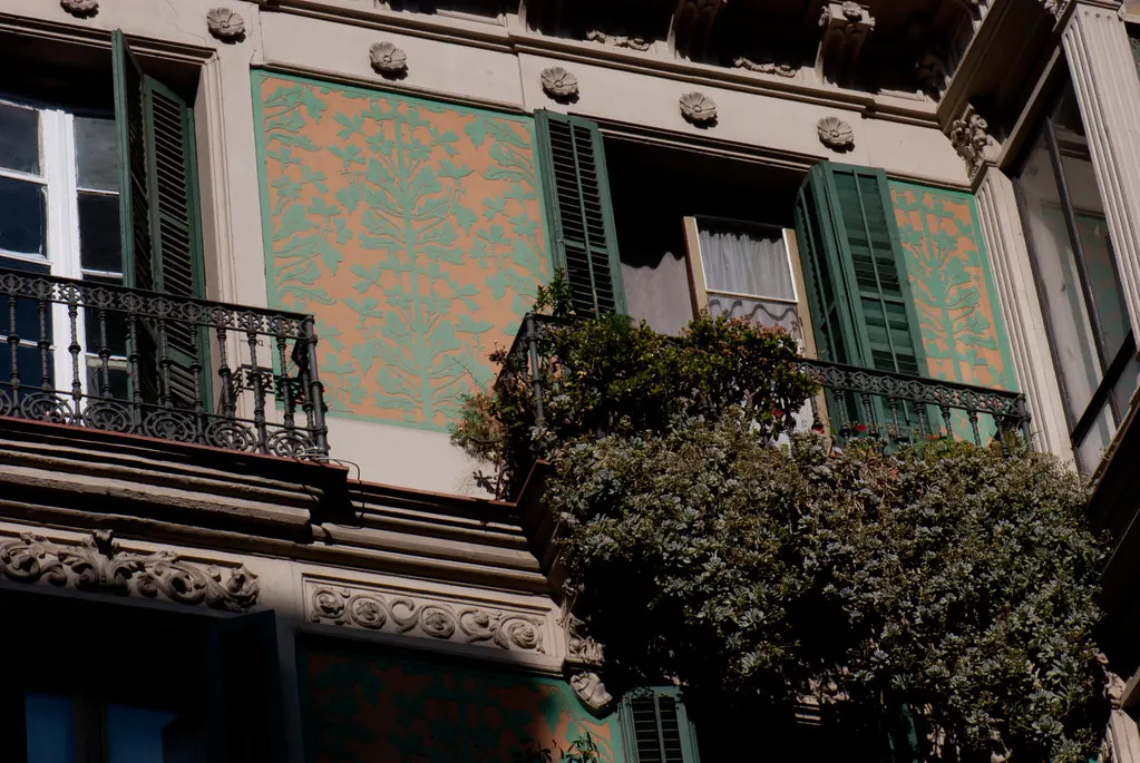 Fachada modernista con balcones de hierro y esgrafiados