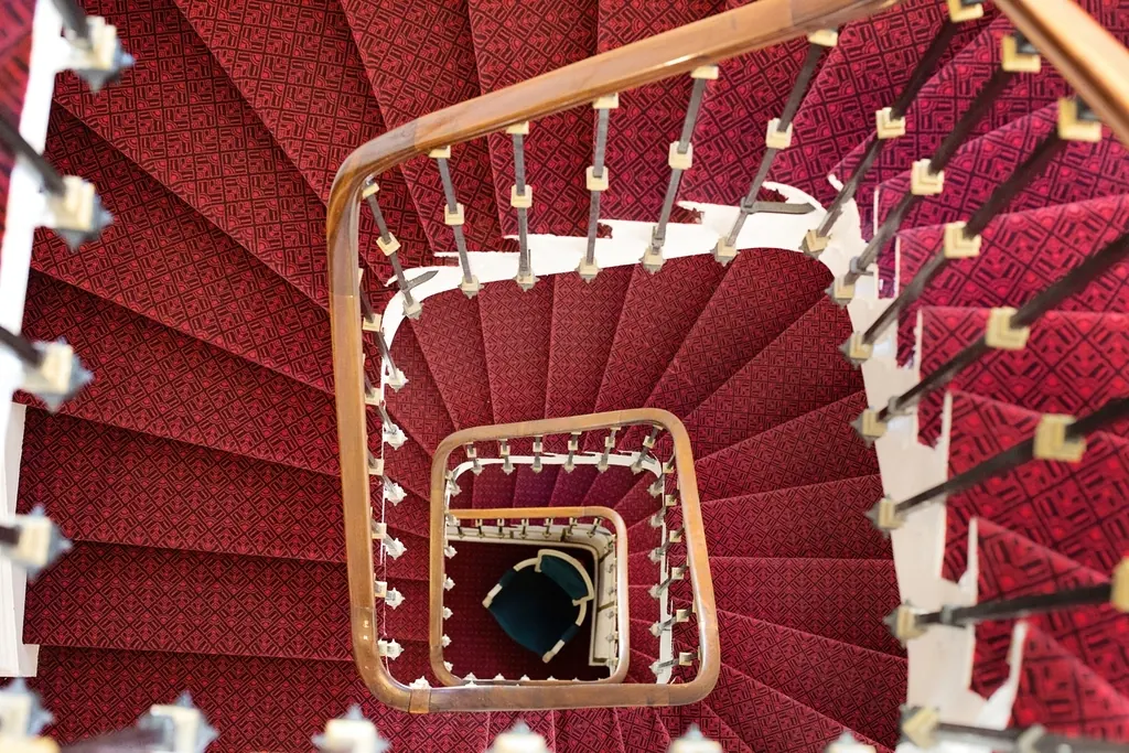 Escalera de caracol con alfombra roja vista desde arriba